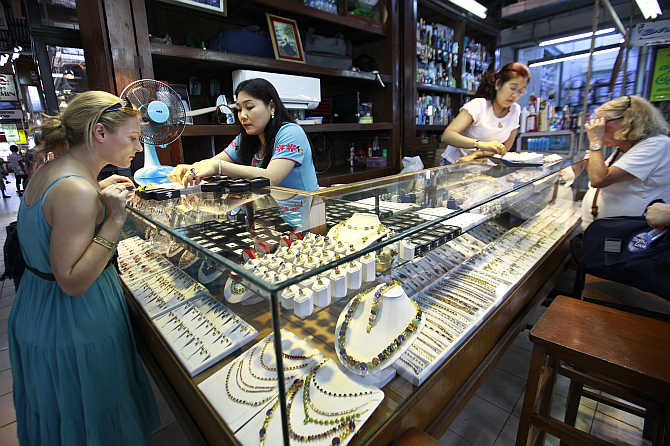 Tourists look at jade and gems in a shop at Aung San market in Yangon, Myanmmar. The Nagarathars moved to Myanmmar in the 19th century.