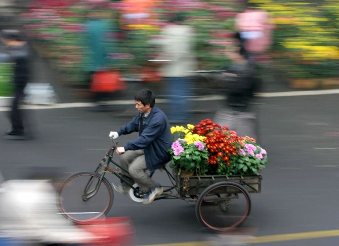 A Chinese man carries flowers in Foshan.