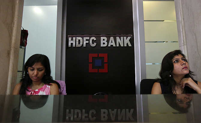 Personal bankers wait for customers at the reception of a HDFC Bank branch in Mumbai.