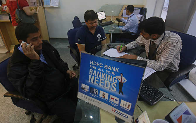 A personal banker speaks to customers inside an HDFC Bank branch in Mumbai.