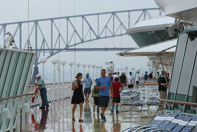 Tourists walk on the top deck aboard the Royal Caribbean cruise ship Grandeur of the Seas en route to Hamilton, Bermuda.