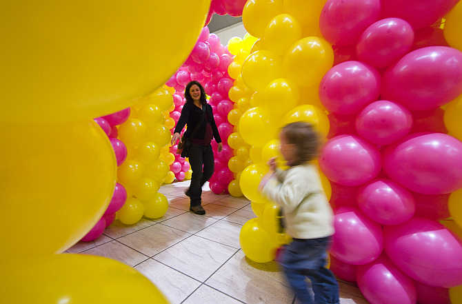 A woman and her child play inside a temporary labyrinth at a shopping mall in Allaman near Lausanne, Switzerland.
