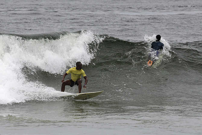 Competitors ride waves at the third annual Surf Liberia Contest at Robertsport in Liberia.