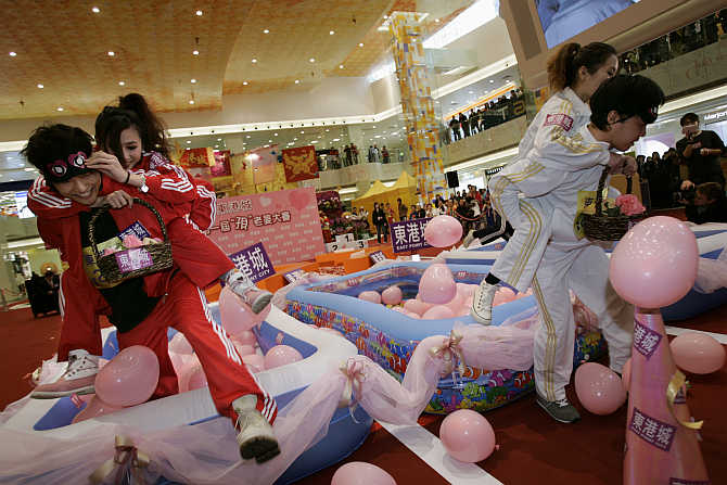 Participants compete in a wife-carrying obstacle race at a shopping mall in Hong Kong.