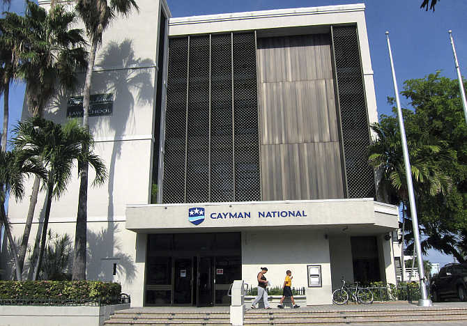 People walk out of a branch of the Cayman National Bank in George Town, Cayman Islands.