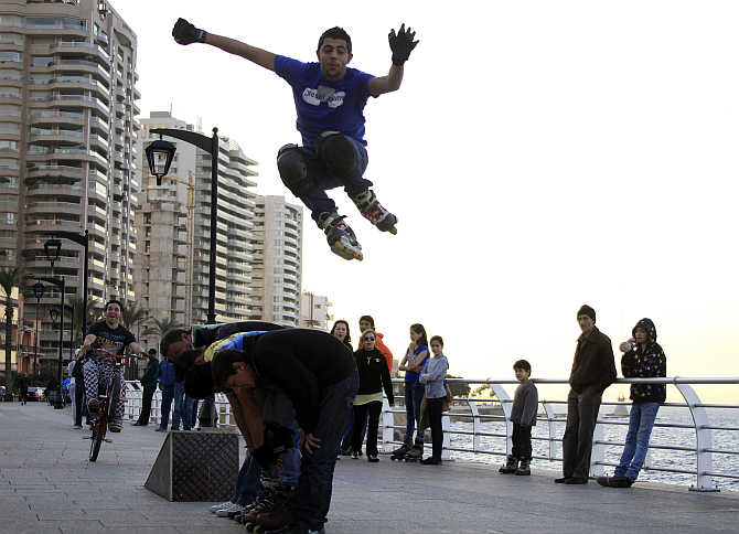 A youth jumps over his friends as he skates on roller blades in Corniche Al Manara on the Beirut Riviera in Lebanon.