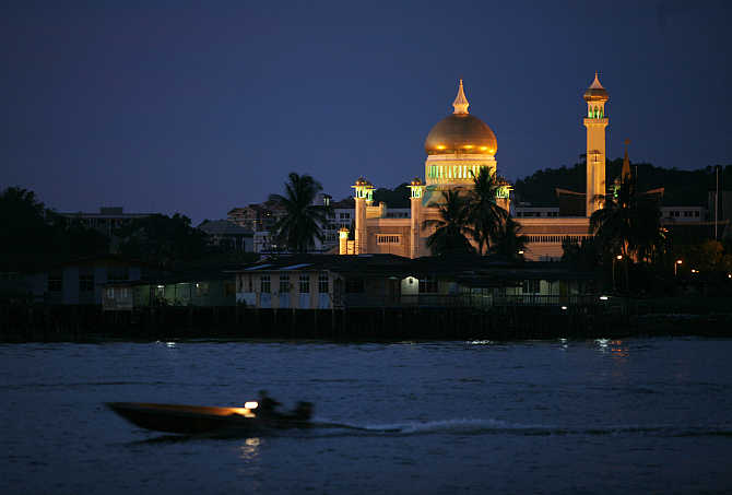 A water taxi passes Brunei's landmark Sultan Omar Ali Saifuddien Mosque in Bandar Seri Begawan, Brunei.