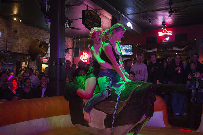 Visitors to a bar ride a mechanical bull on Sixth Street in Austin, Texas, United States.