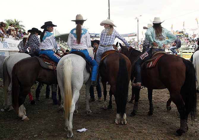 Competitors look on from their horses before competing in the Cowgirl World Championship in Villavicencio, Colombia.