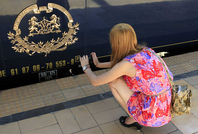 A woman takes a picture of the logo of the Orient Express luxury train at the main railway station in Bucharest, Romania.