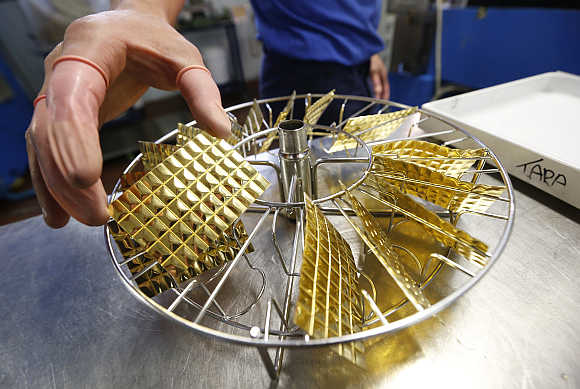 An employee holds a gold Combibar in Balerna, Switzerland.