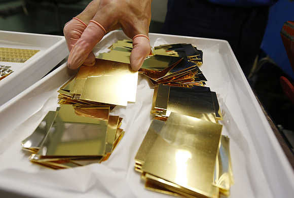 An employee holds an unpressed gold Combibar in Balerna, Switzerland.
