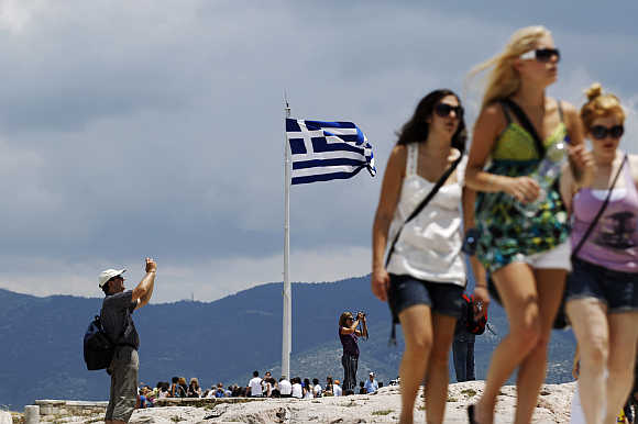 Tourists visit the archaeological site of the Acropolis hill in Athens.