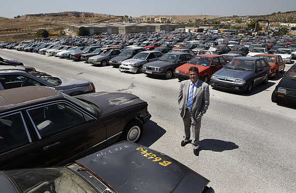 Oddy's Manager Dimitris Kouvaris amid confiscated cars in the yard in Athens.