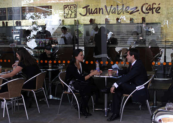 A couple chat as they drink coffee at Juan Valdes cafe in Bogota.