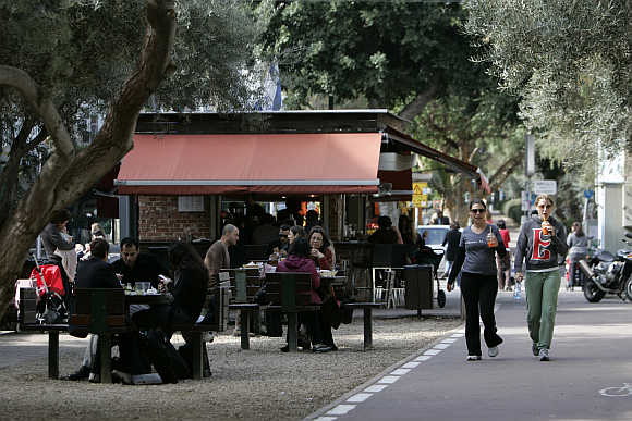 People walk past a cafe in Tel Aviv.