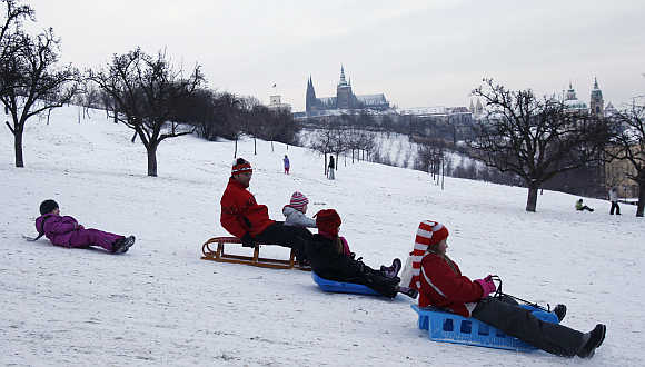 People slide down a snow covered Petrin hill in Prague.