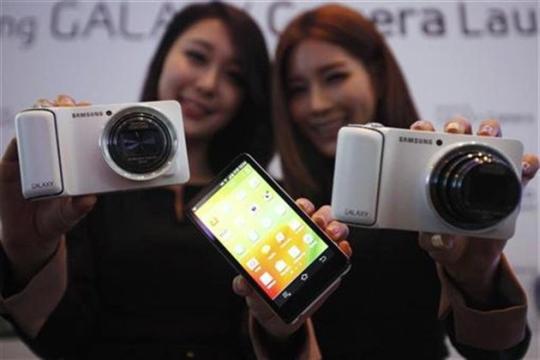 Models pose with sets of Samsung Electronics' Galaxy Camera during its launch event.