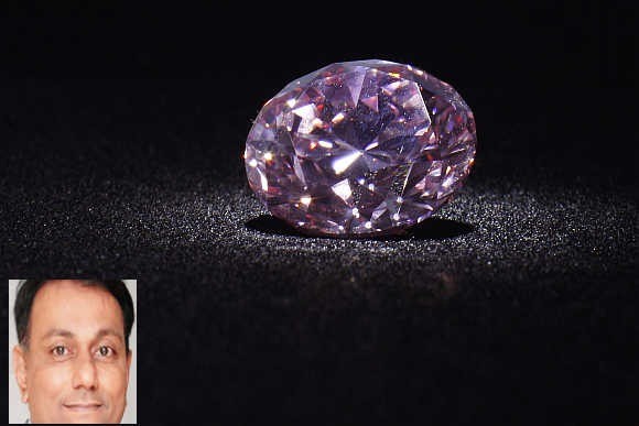 'Martian Pink', a 12.04-carat Fancy Intense pink (Type IIa) diamond, is shown during a media preview at Christie's in Hong Kong. Dharmesh Shah, inset.