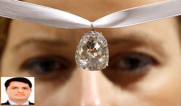 An employee of Sotheby's auctioneers displays the Beau Sancy diamond in Zurich, Switzerland. Ashok Gajera, inset.