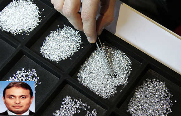 A vendor inspects 0.20 carat diamonds during the Antwerp Diamond Trade Fair in Belgium. Russell Mehta, inset.