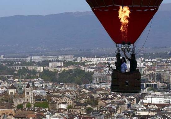 balloonist uses his burner during a flight above the city of Geneva.