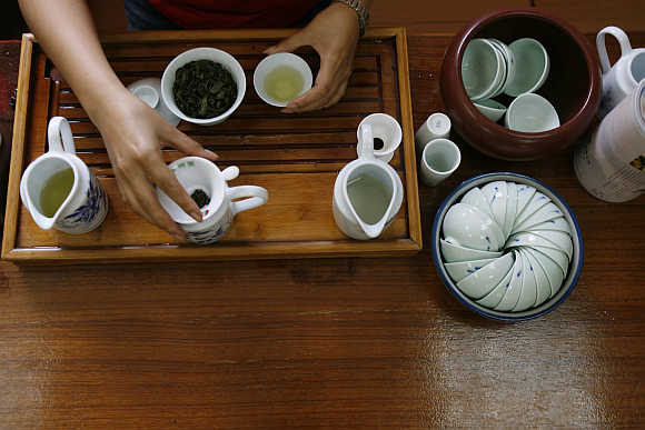 A woman prepares 'Bao Zhong' tea using a traditional tea set in Pinglin. The small town is one of Taiwan's major tea growing areas and is located in the mountains which provides an ideal climate for growing tea.