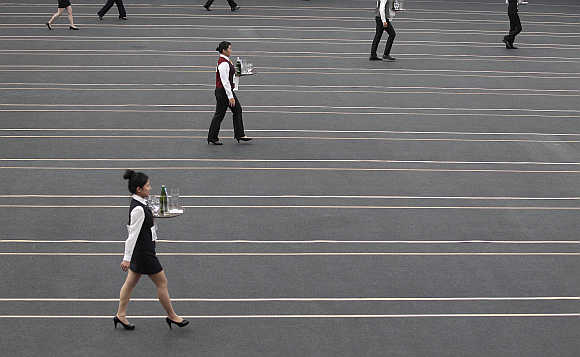 Contestants race with trays containing beer bottles and glasses during the Wowprime tray carrying competition in Taipei, Taiwan. Over 1,200 waiters and waitresses from around Taiwan compete in the race based on speed, grace, and accuracy for prizes worth about $8,200 and working opportunities at restaurant chain operator Wowprime Corp.