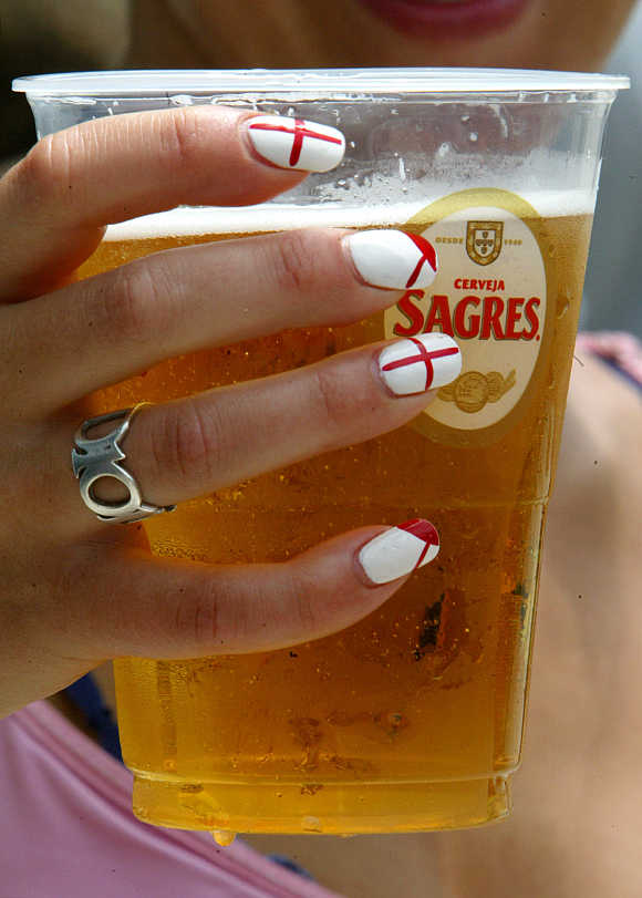 A England fan holds a glass of beer in the centre of Lisbon, Piortugal.