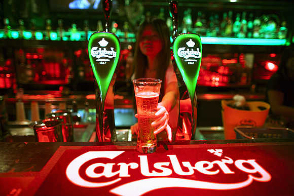 A bartender serves a beer at a bar in Kuala Lumpur, Malaysia.