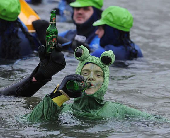 A swimmer wearing a costume drinks beer while swimming in the near-freezing water of the river Danube in Neuburg an der Donau, Germany.