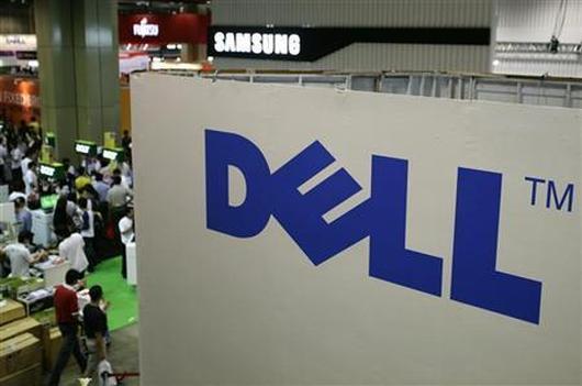 Shoppers walk past a Dell booth.