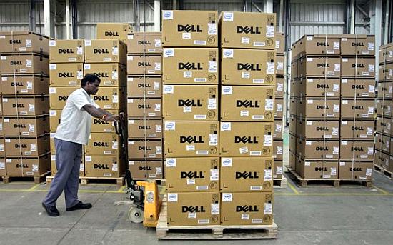 A man pushes a trolley full of Dell computers through a company factory.