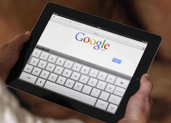 A woman surfs Google home page on an Apple Ipad.