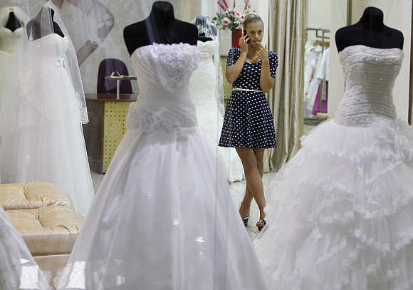 A shop assistant talks on the phone at a bridal gown store in a shopping mall in Kiev, Ukraine.