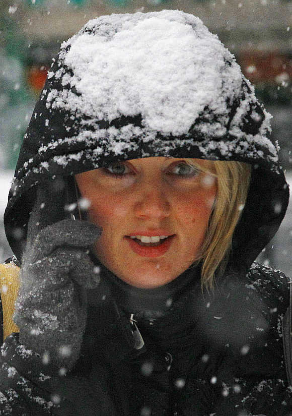 A woman speaks on her mobile phone as she walks during snowfall in Edinburgh, Scotland.