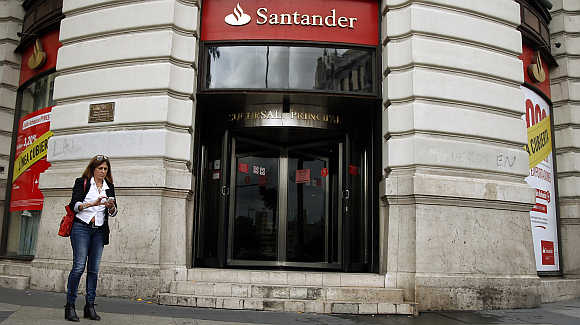 A woman uses her mobile phone outside the main branch of Spain's Santander bank in Madrid.