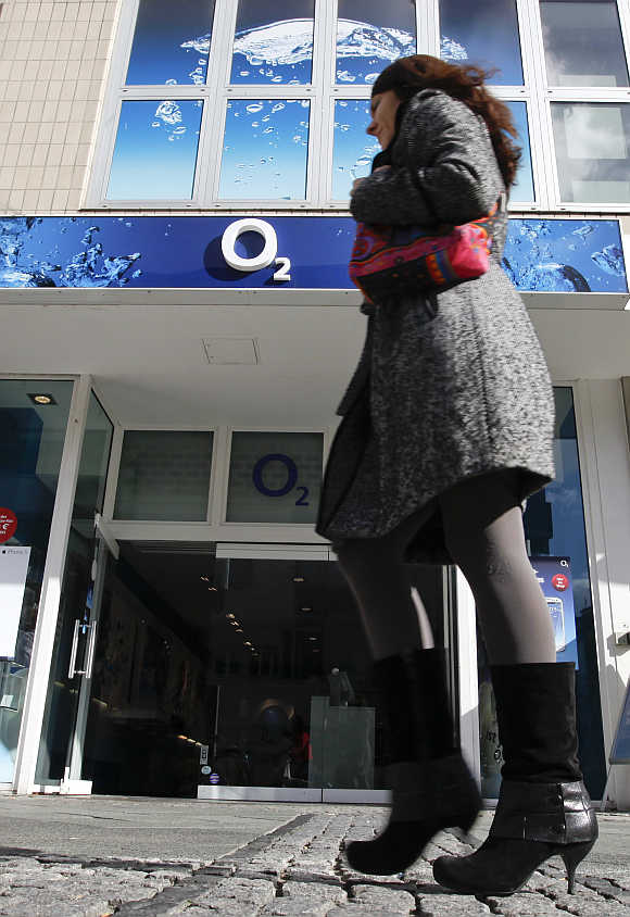 A woman passes by a German mobile phone group O2 shop at Wilmersdorfer shopping street in Berlin.