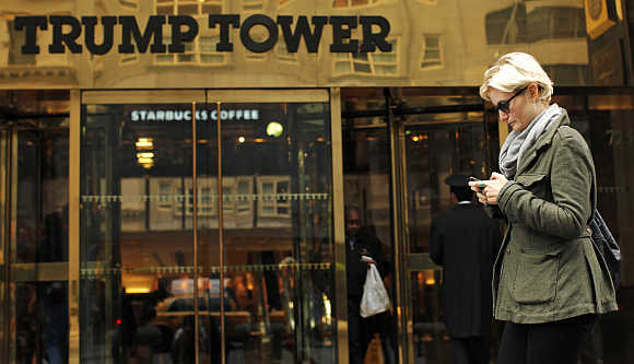 A woman uses her mobile phone in front of the Trump Tower in New York.