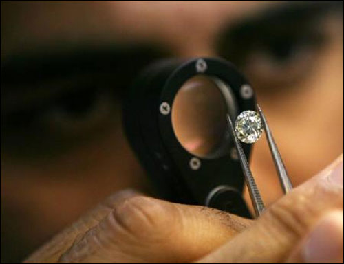 A diamond merchant desmonstrates a process at a diamond cutting and polishing factory in Surat, Gujarat.
