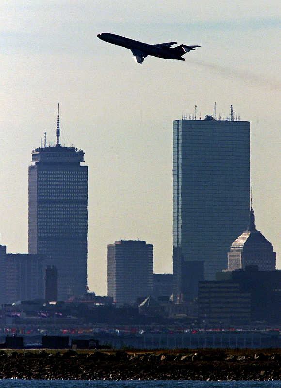 A plane passes Boston's Prudential, left, and John Hancock, right, towers as it takes off from Logan International Airport.