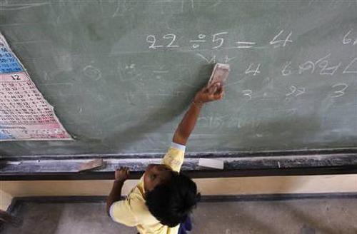 A student cleans a blackboard at a school.