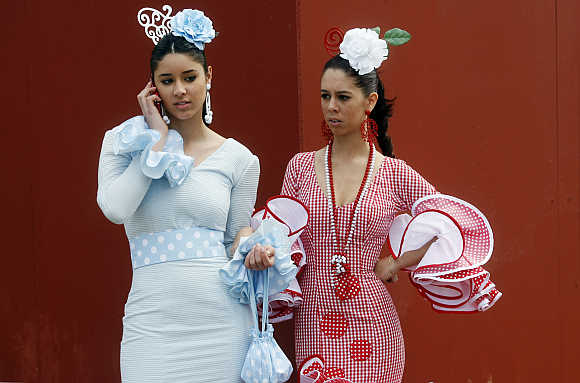 Women wearing Sevillana dresses take part in the April fair in Seville.