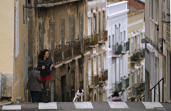 A woman walks her dog in Lisbon.