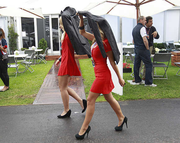 Women cover themselves from rain in Melbourne.
