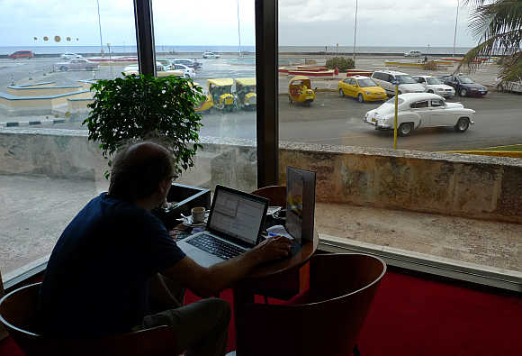 A man surfs the Internet using a wireless connection in the lobby of a hotel in Havana, Cuba.