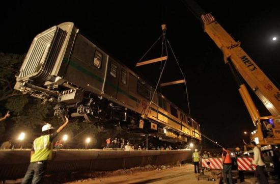 A Metro rail carriage is lifted on to a track.