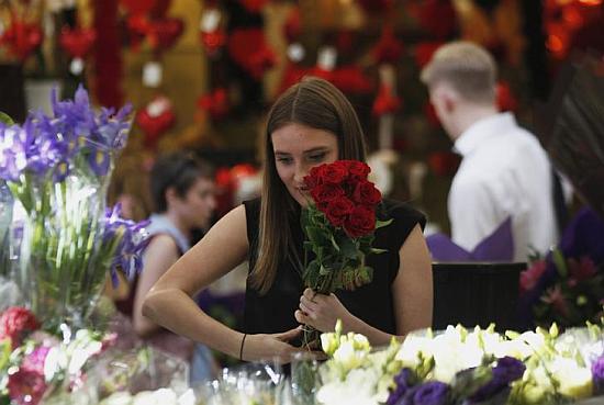 A worker prepares a red roses bouquet to be sold as a Valentine's Day special.