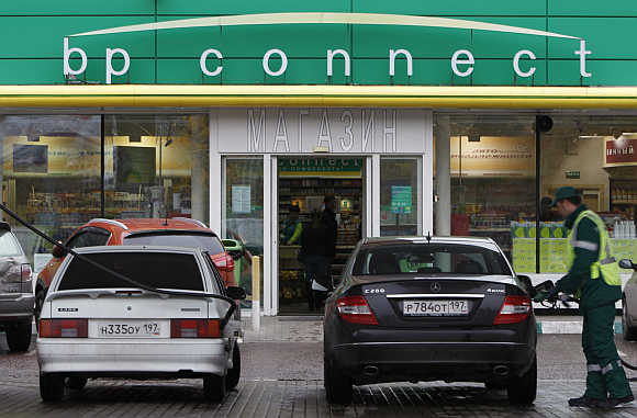 A pump attendant fills cars at a petrol station in Moscow.