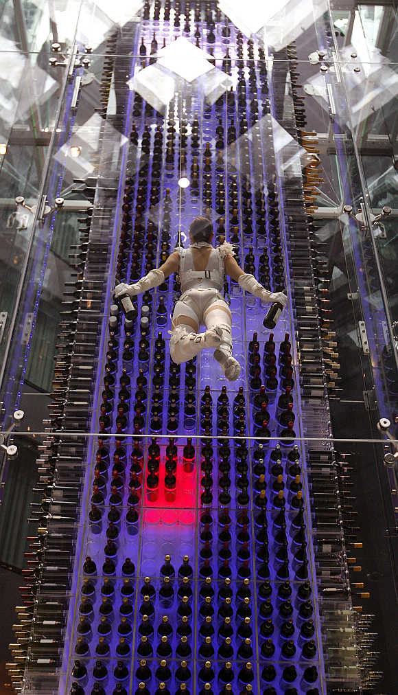 A so-called 'wine angel' carries two bottles of wine as she is suspended by steel ropes and lifted up by a motorised winch in front of a wine storage tower in the lobby of the Radisson Blu Hotel at Zurich airport.